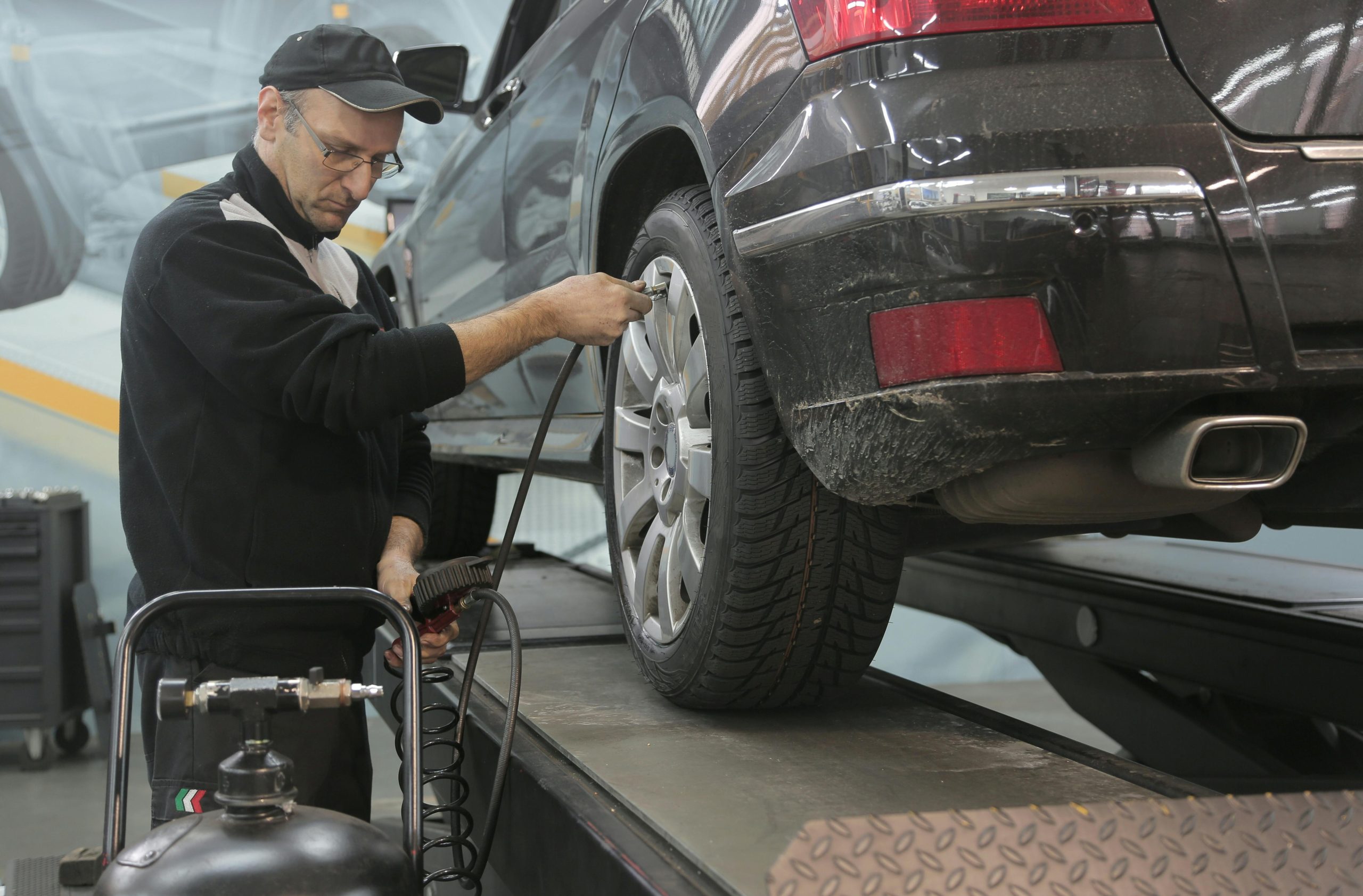 Technician servicing a tire next to a car lift