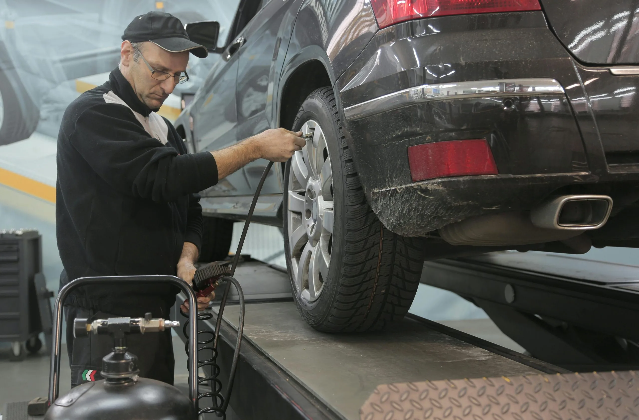 Technician servicing a tire next to a car lift
